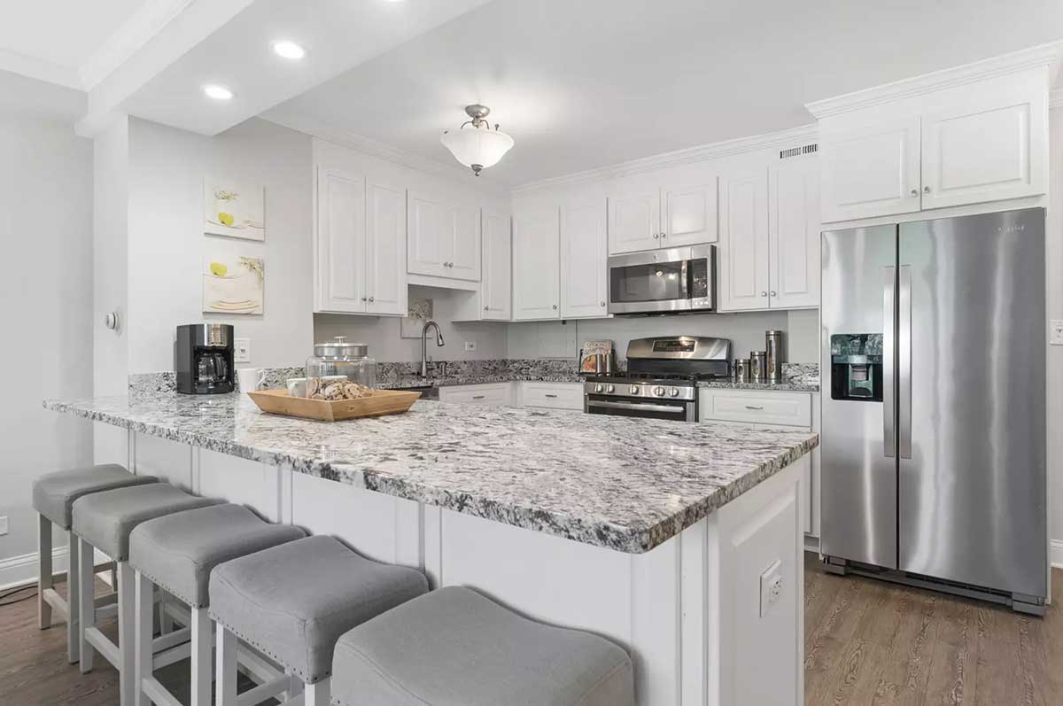 The kitchen at 850 North Dewitt Place Unit 4H in Chicago's Streeterville neighborhood. Listed for sale by The DelGreco Team from Coldwell Banker Realty's Lincoln Park Office. The kitchen is all white with white cabinets and stainless steel appliances