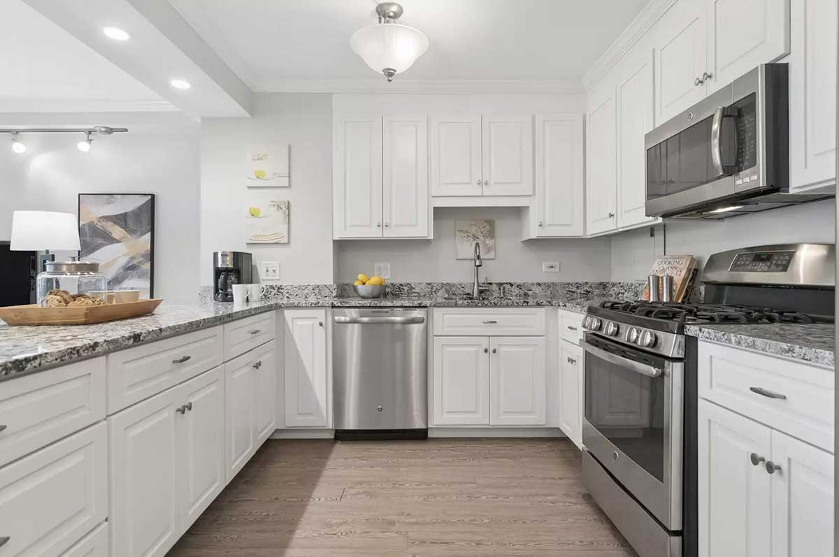 The kitchen at 850 North Dewitt Place Unit 4H in Chicago's Streeterville neighborhood. Listed for sale by The DelGreco Team from Coldwell Banker Realty's Lincoln Park Office. The kitchen is all white with white cabinets and stainless steel appliances